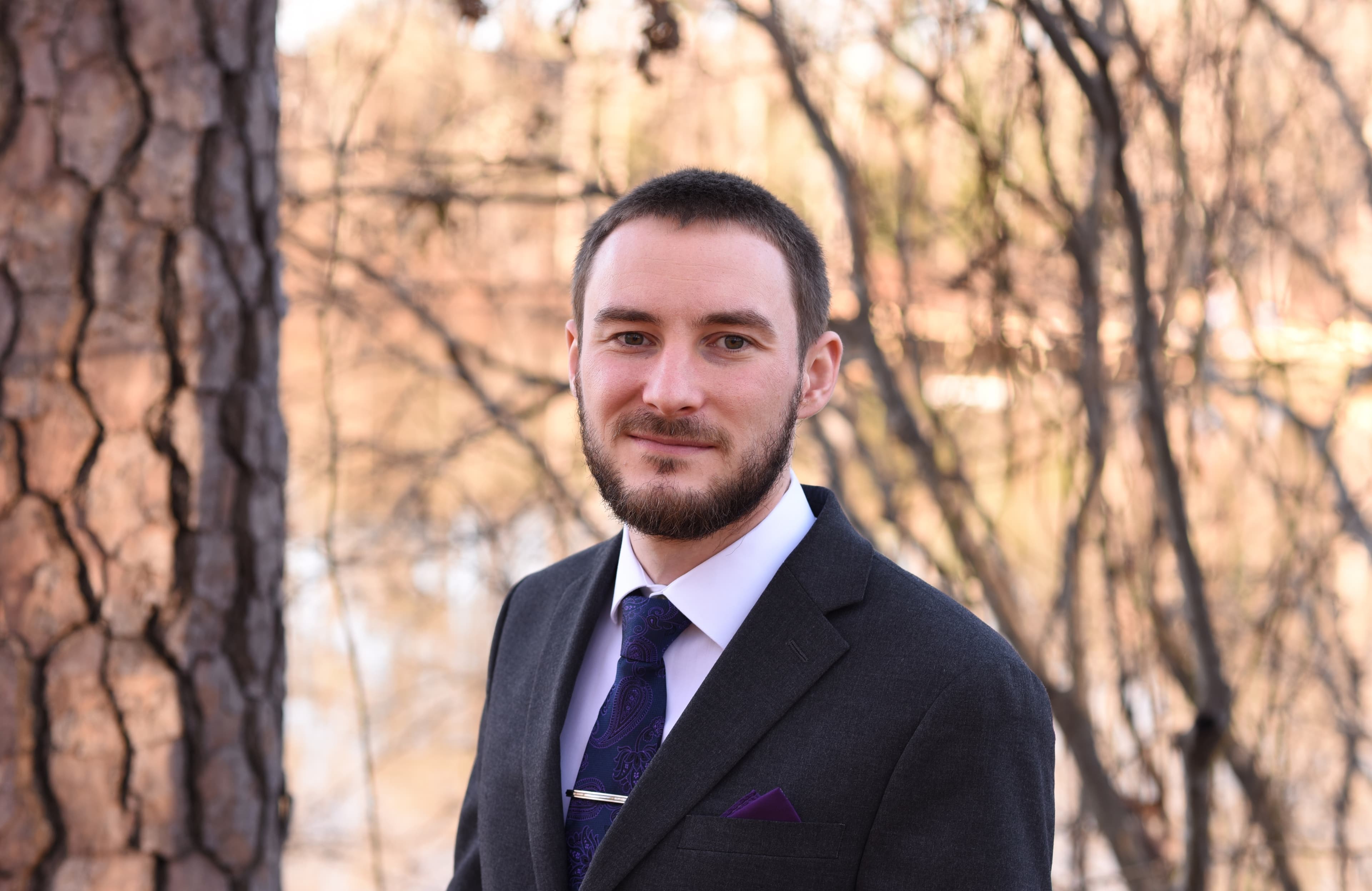 Headshot of Stephen Rast, candidate for Supervisor. The background is a forest and lake scene.